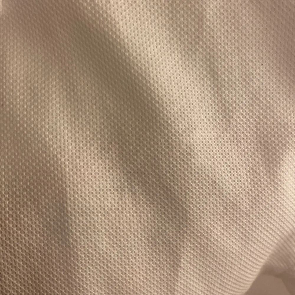Vit slim fit oxfordskjorta i strålande skick. Inga defekter förekommer. Rutig textur (se bild 2)  Ärmlängd: 63 cm Axel-axel: 45 cm midja: 95 cm Längd (rygg): 74 cm. Skjortor.