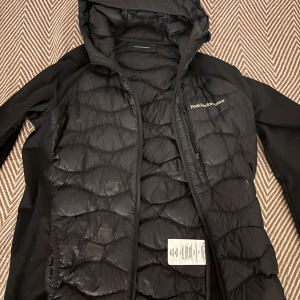 Peakperformance helium down hybrid Hood jacka - Säljer en Peakperformance jacka Några skador täckt med svart tejp knappast mycket bara små mini hål vid fickan som man kan se pgr av raketer men annars funkar fint 