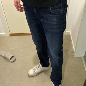 Ett par Lee (Austin) Jeans i mörkblå färg i storlek W32 L32 som jag växt ur. Slim fit.