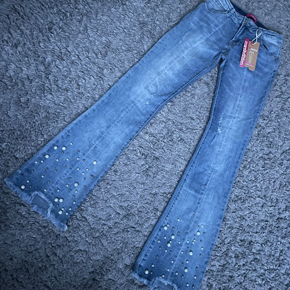 Lågmidjade bootcut jeans med detaljer  Midjemåttet 35  Innerbenslängd 81  Ytterbenslängd 104. Jeans & Byxor.
