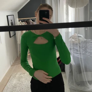 Grön långärmad top - Fin grön top med en detalj över bröstet. Använd ca 3 gånger, så i väldigt fint skick. Stickad men är lika tjock som en baströja