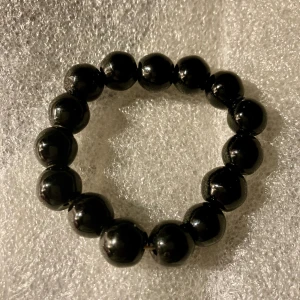 Svart armband  - Armband, stretchigt pga elastisk tråd, svarta glaspärlor. Finns ngra pytterepor, syns knappt. 