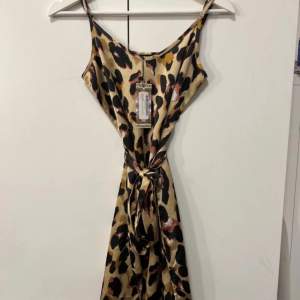 Helt ny leopardmönstrad klänning i satinmaterial från Boohoo. Prislapp kvar passar Xs/Xxs. 