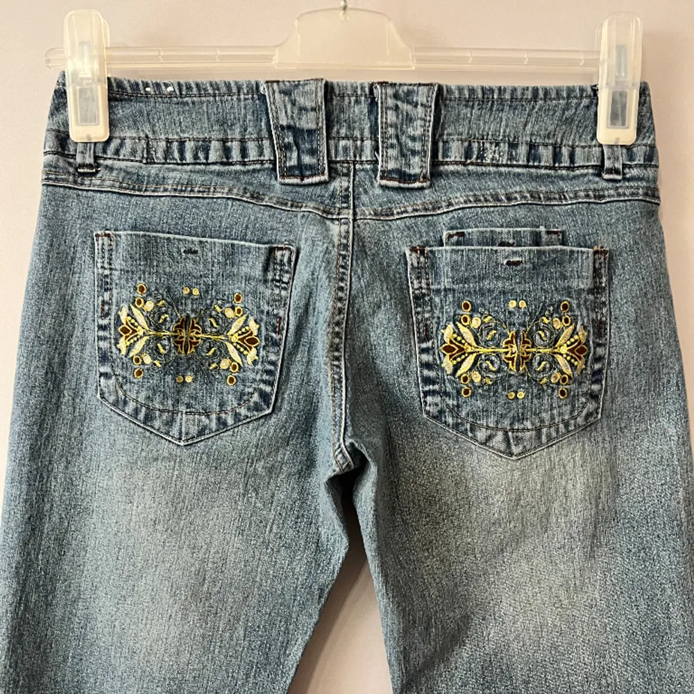 Ljusblå jeans i nästan helt nytt skick! 9/10.  Gult blommotiv på bakfixkorna.  Står size 5 som ungefär är W27. De är ca 39cm rakt över midjan och innerbensmåttet är ca 79cm. Frågor och prisförslag välkomnas.  18. Jeans & Byxor.