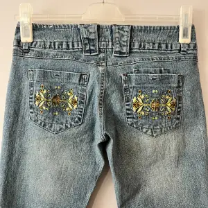 Ljusblå jeans i nästan helt nytt skick! 9/10.  Gult blommotiv på bakfixkorna.  Står size 5 som ungefär är W27. De är ca 39cm rakt över midjan och innerbensmåttet är ca 79cm. Frågor och prisförslag välkomnas.  18