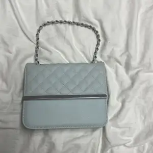 En baby blå väska med silver detaljer, använd Max 5 gånger, pris går att diskutera 