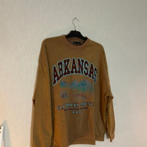 T-shirt - Helt ny T-shirt från ASOS DESIGN - Bruntvättad, längärmad t-shirt i oversize med retro stadstryck pa bröstet, då returtiden har passerat 