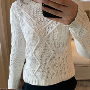Stickad tröja - Vit stickad tröja i storlek 152 men skulle säga att den motsvarar en xxs-xs. Den är kabelstickad och i bra skick. 