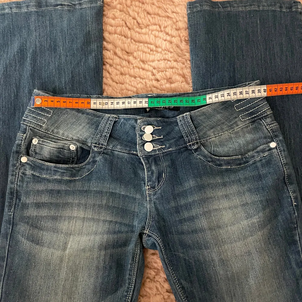 Lågmidjade bootcut jeans med snygga detaljer på fickorna och knapparna. Midjemåttet är 39 cm, innerbenslängd 81 cm. Bra i längden för mig som är 174💗Stretchigt material🤍Pris går absolut att diskutera! Skriv privat för funderingar🫶🏼. Jeans & Byxor.