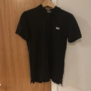 Snygg t-shirt helly Hansen  - Snygg t-shirt helly Hansen äldre variant storlek s den har tappat lite färg i nacken men ingen man tanker på går lätt att färga om med svart färg storlek s men passar också