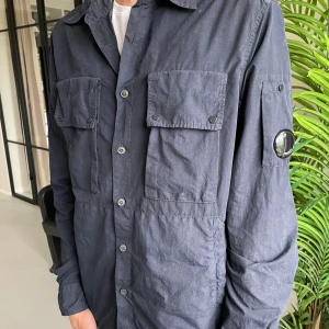 CP-company overahirt - Marinblå overshirt från C.P company. Overshirten är i mycket bra sick utan några defekter. Ordinarie pris ca 2500kr.  
