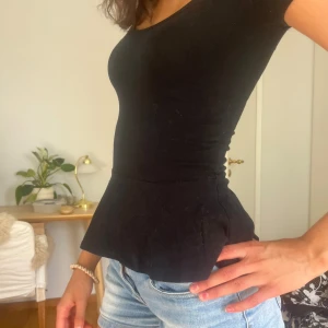 Svart peplumtopp med fin figur - Super söt utsvängd t-shirt köpt på Plick❤️ 