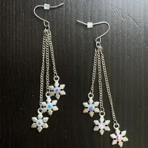 Silverfärgade örhängen, snöflingor, strass, silver, hängande, kedja, - Silverfärgade örhängen med strass som gnistrar i olika färger, finns tecken på användning. Längd: 8 cm.