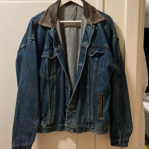 Jeansjacka med skinndetalj - En snygg vintage jeansjacka med bruna skinndetaöljer. 