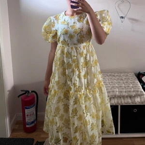 Långklänning  - Maxiklänning från Copenhagen Muse. Dekorerad med fina gula blommor. Använd ett fåtal gånger 