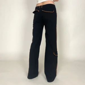 Byxor - Coola byxor med orangea detaljer! Midjemått: 85-99cm Innerbenslängd: 83cm. De är strl 42 men är väldigt stretchiga. Jag på bilden har strl 38 på underdelar och är 170cm lång. Klicka på köp nu <3