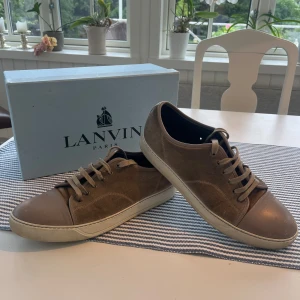 Lanvin Beige - Lanvins i beige färg som upplevs ljusare i verkligheten. Storlek 11 men motsvarar eu ca 45-47.  Skorna är i använt skick men blir fräscha efter en tvätt.   Box medföljer