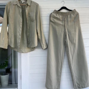 Linneset med skjorta och vid byxa  - Så gott som nytt linneset med skjorta och byxor i naturfärg, ljus beige/grön/kaki. Storlek XS men byxorna har resår i midjan så funkar på en S också, 300kr. Perfekt nu i sommar!