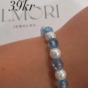 Blått och vitt armband från Almori - Ett elegant armband från Almori med blå och vita pärlor. Armbandet har en enkel och stilren design som passar till både vardag och fest.