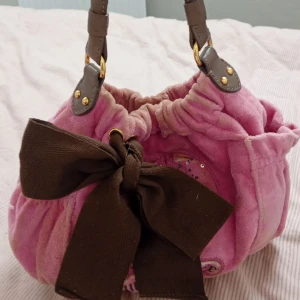 Juicy couture väska - En rosa vintage juicy couture väska lite sliten för den är gammal men annars bra skick, skriv för frågor 🩷