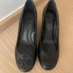 Tory Burch Wedge heel - Black leather Tory Burch Wedge heels. As new with size sticker on bottom of shoe!  Size 6,5 (us) - 37 (eu)