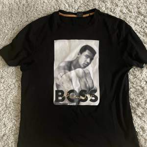 snygg och sällsynt t-shirt från hugo boss med muhammed ali tryck som inte säljs längre! Storlek S men sitter som M och som på bild så sitter den bra på mig som är runt 183!  skick: 9/10 nypris:899kr  