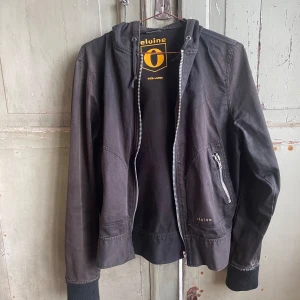 Elvin - Elvin jacka med huva. Väl använd under ett par år. Några småskavanker annars helt ok.