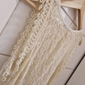 Romantisk topp (Nyskick) Strl M - Romantisk topp  Strl M Nyskick! Färg: Creme Mirelle  Underbar topp i romantisk stil med vackra detaljer. Ryggen är i spets. Pärlor invirkade vid ärmsluten. Så otroligt fin! Endast använd två ggr.