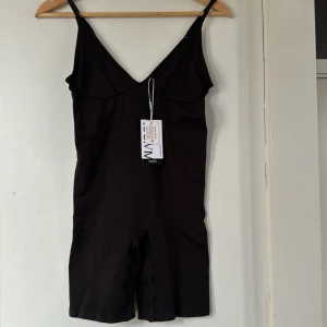 Svart body, Shapeware M/L - VMSILLA DEEP SHAPE från Vero Moda i storlek M/L. Bara provad, prislapp kvar. Tyvärr för kort i livet för mig, är 176cm för referens. Går att få fler bilder om så önskas. Nypris 375kr.  Pris kan diskuteras.