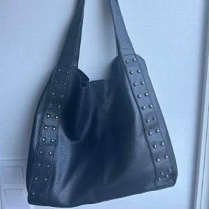 Svart handväska  - Super bra o fin handväska, har ett fack i mitten och passar perfekt som tex skolväska eller annat. En knapp har lossnat som man ser på bild annars super bra skick🥰