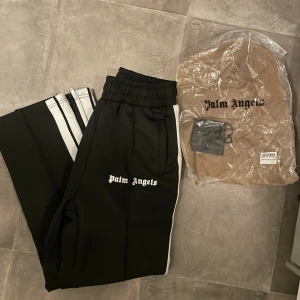 Palm Angels - Dessa nya Palm Angels byxor kombinerar urban stil med hög komfort. De är designade med Palm Angels’ signaturdetaljer och är perfekta för både avslappnade och mer uppklädda tillfällen.