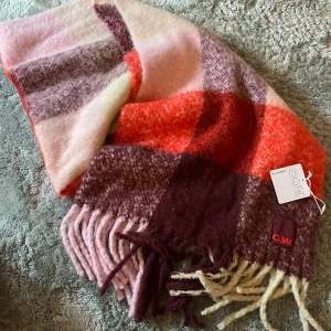 Halsduk Carin Wester - Säljer en helt ny oanvänd halsduk i superfina färger! Röda, vinröda, ljusrosa och lila toner!❤️ Prislappen finns kvar och nypriset är 399kr!❤️