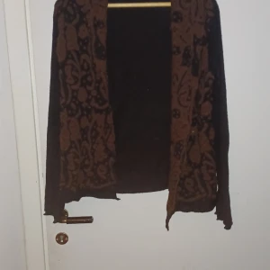 Kofta svart/brun - Kofta med coola bruna detaljer på framsidan. Storlek M - XL, stretchig material 