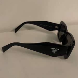 Äkta Prada solglasögon - Använda fåtalet gånger men har några rispor. Oöppnad putsduk, kvitto, originallåda mm. medföljer. Nypris 2.100kr.
