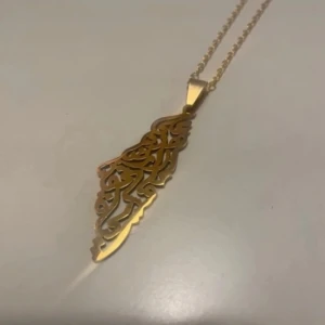 Halsband Palestina  - Jättefint halsband med Palestinamotiv. Kedjan är 50 cm och hänget 5 cm. Nytt i förpackning. 