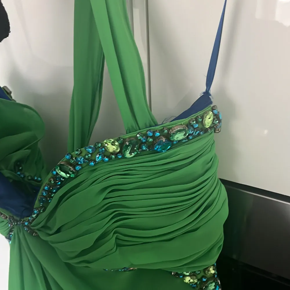 En fin grön klänning med diamanter som kan användas vid bal, event, galor m.m. Man kan bära den ärmlös eller med band som de på den sista bilden. Endast använd en gång, köpt för 1200kr men säljer för 600 då det var längesen den köptes. Klänningar.
