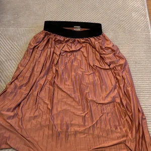 Långkjol  - Lång satin kjol med svart resårband i midjan. Strl xs