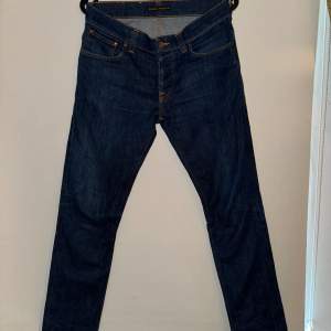 Jätte snygga nudie jeans i väldigt eftertraktad modell Grim Tim. Passformen är slim fit och skicket är 9.5/10 har haft på de 2 gånger. Ny pris ligger runt 1600. Storlek W32 L32