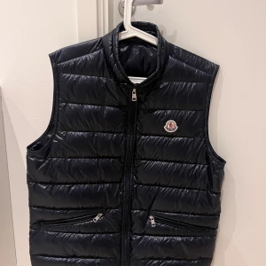 Moncler väst - Säljer min moncler gui i storlek 4, Navy blue. Eftersom den var för liten. Västen är aldrig använd och är 10/10 skick. Västen är köpt på NK i Stockholm. Kvitto och påse medföljer såklart. Det är bara att höra av er för mer info.