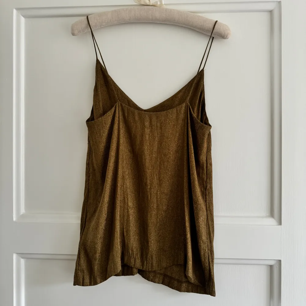 Olivgrönt silkigt linne som skiftar i brons. Tunt och ser lyxigt ut. Perfekt till sommaren 🤎  Material polyester. Toppar.