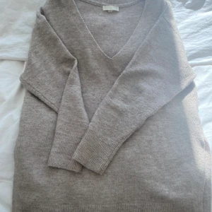 Stickad tröja  - Beige stickad tröja med v ring och slits i sidorna lik den i andra bilden storlek xs