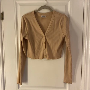 Beige tröja - Beige tröja med knappar som inte kommer till användning.