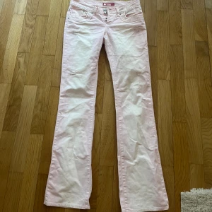 Rosa Lågmidjade jeans - Så snygga Lågmidjade utsvängda jeans. Dem är ljusrosa. Midjemått 38 cm och innerbenslängd 80 cm