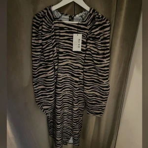 Ny zebramönstrad klänning  - Så fin klänning från Na-kd i storlek 36, ny med lappar🤍 Puffiga ärmar, slits på ena sidan, dold dragkedja i sidan.