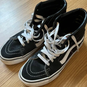 Vans skor - Vans sk8hi svarta i jätte bra skick förutom att den vita delen längst ner på Akon är lite smutsig annars topp skick. Inte änvända på 3 år eftersom att de är för små. Sko låda ingår och jag är öppen för pris förslag❤️