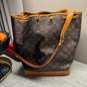 Louis Vuitton Noe bag - Säljer min fina Louis Vuitton väska. Inköpt för lite mer än ett år sedan från Vestiaire collective för 8000 kr. Mått är 27x34x19. Det är den vanliga stora modellen. Får plats med dator. Slitage på väskan har kommit med tiden, äkta vintage väska!💕💕