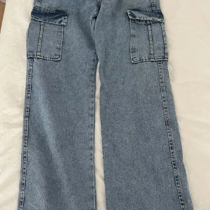 Jeans - Högmidjade jeans med fickor på sidorna som ger en snygg passform.