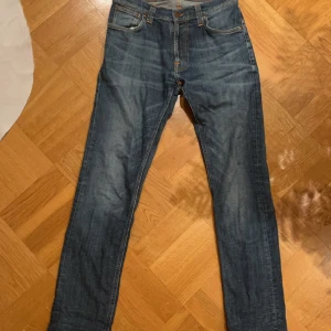 Nudie Jeans - Vi säljer ett par feta nudie jeans i färgen mörk blå faded för endast 419kr. Orginal pris ligger på 1399kr. Storlek 31/32. 