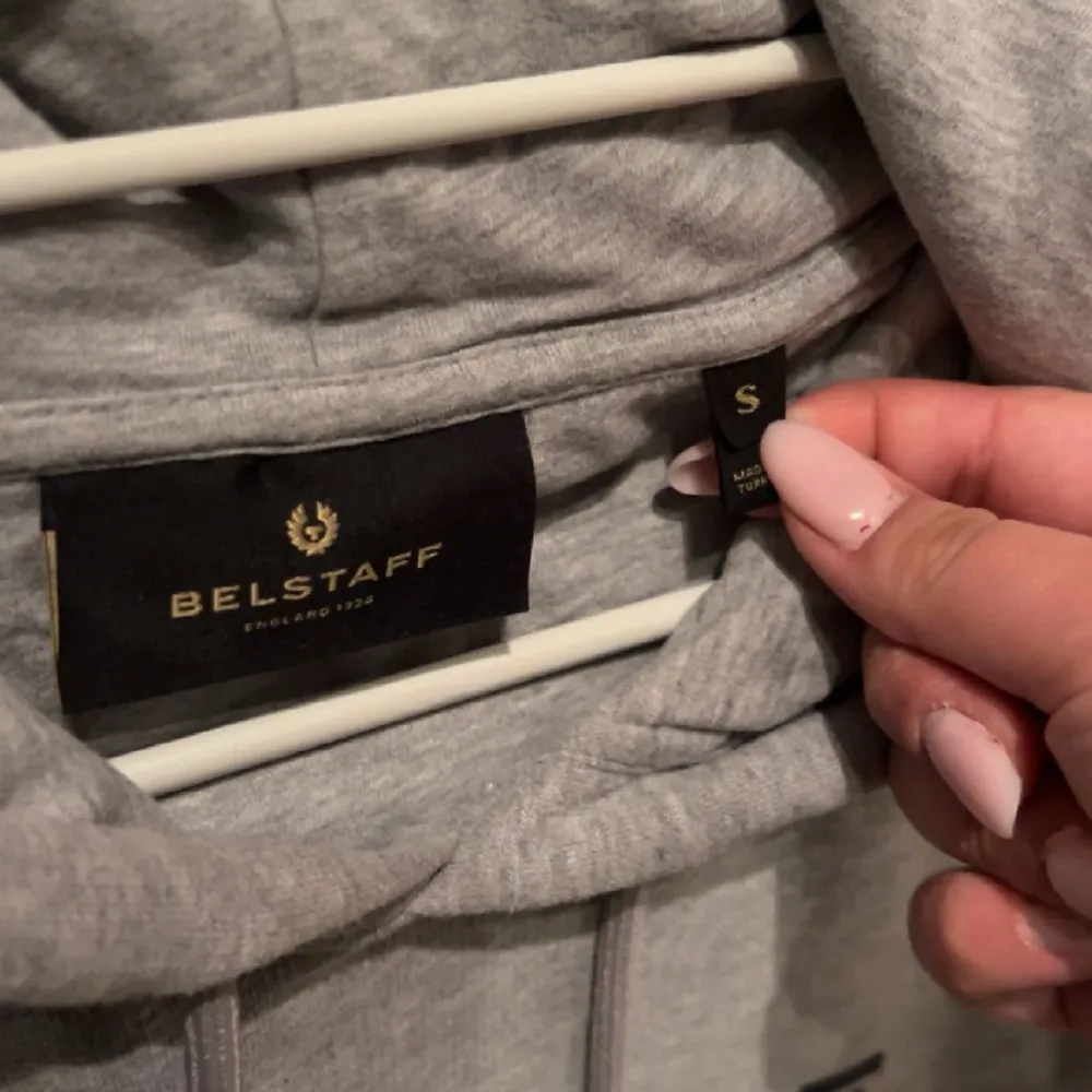 En snygg grå märkes hoodie som är bekväm men jag har tyvärr vuxit ur den. Märket Belstaff, nypriset ligger på 1000kr+ där någonstans. Fint skick Storlek Small.. Hoodies.