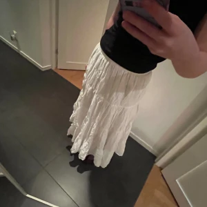 VIT LÅGMIDJAD LÅNGKJOL - Vit lågmidjad långkjol, bra skick, använd endast en gång, storlek 42/44 men passar mindre. 